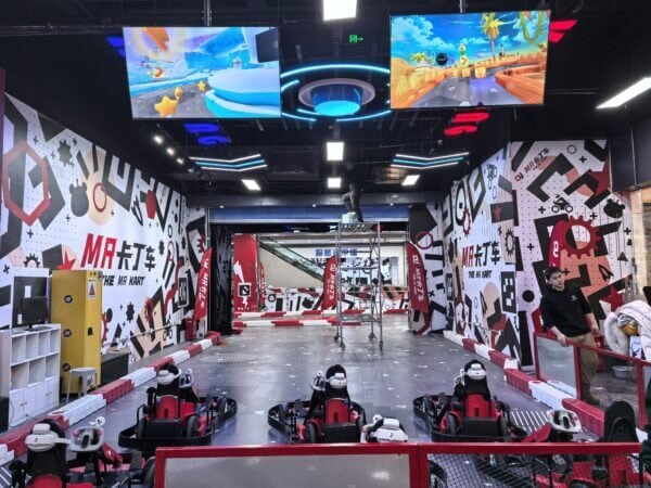 MR GO KART indoor amusement center Indoor go-kart racing track with vibrant decor and safety gear.