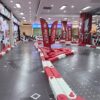 MR GO KART Indoor Racing Track Indoor go-kart racing track with vibrant red and white barriers, featuring sharp turns and dynamic design elements for an exciting racing experience.