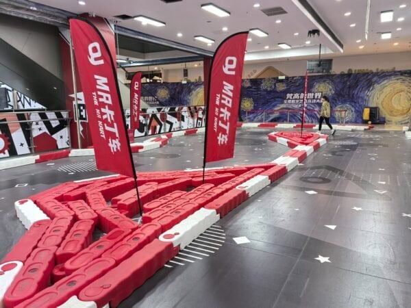 Indoor MR GO KART racing track with red barriers and flags at a shopping mall. Indoor MR GO KART racing track with red barriers and flags at a shopping mall. Perfect for family entertainment and fun racing experiences.