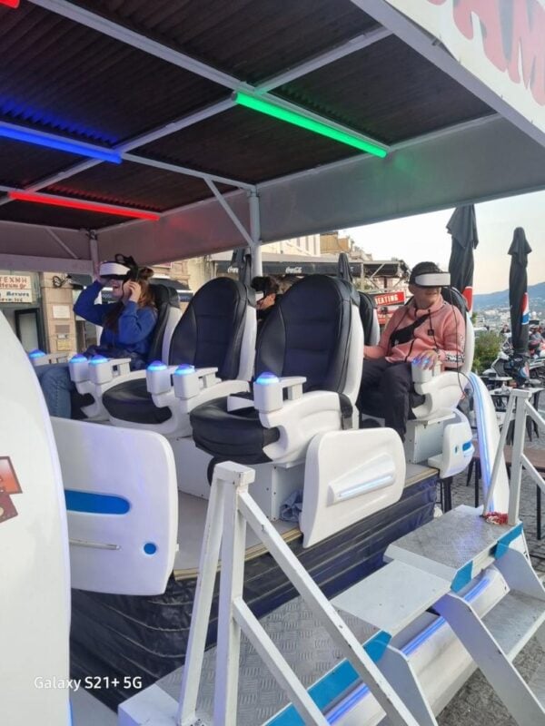 Thrilling VR Ride. Immersive virtual reality roller coaster experience with advanced VR headsets and comfortable seats, providing visitors an exciting adventure at an outdoor amusement area, perfect for thrill-seekers and VR enthusiasts.